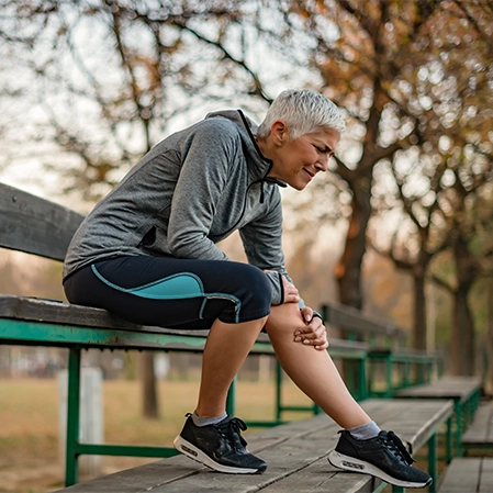 Woman With Knee Pain On A Bench