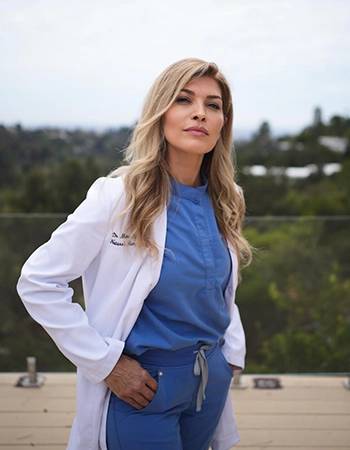 Chiropractor Mitra Razipour Smiling In Blue Scrubs